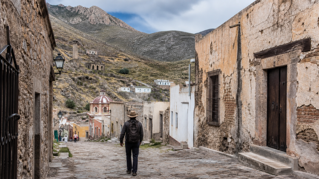 Calle empedrada de Real de Catorce con antiguos edificios mineros y montañas del altiplano